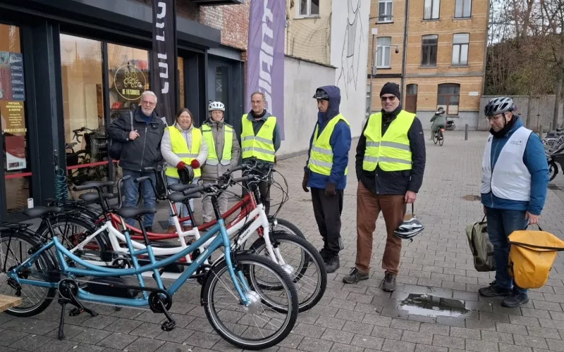 Groep tandemmers aan fietsenwinkel met 3 tandems