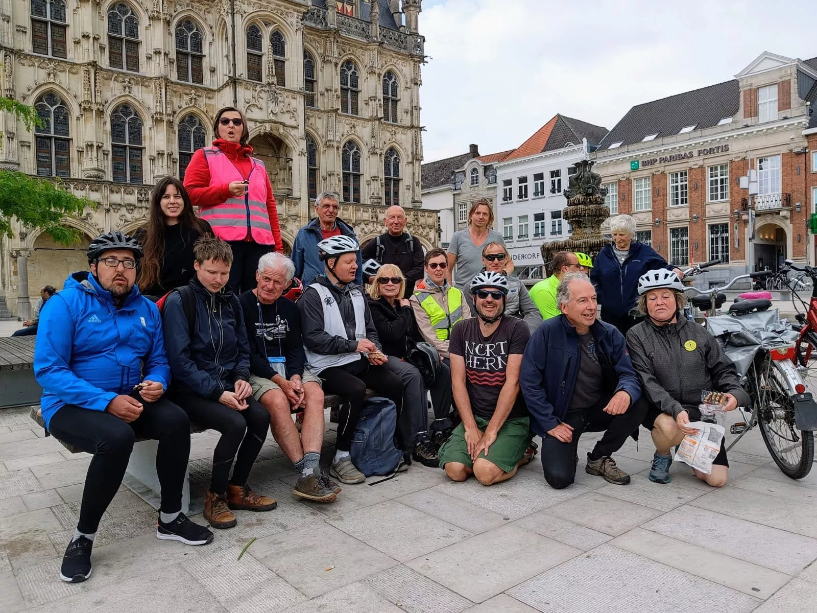 Groep fietsers die poseert voor een kerkgebouw