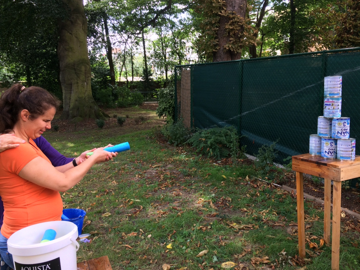 blikjes omver schieten met een waterpistool    