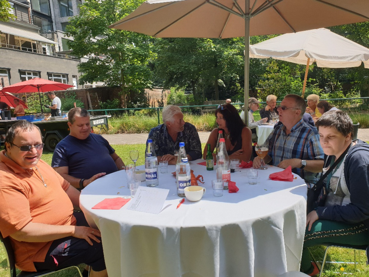 Iedereen aan tafel zit naast elkaar in de schaduw