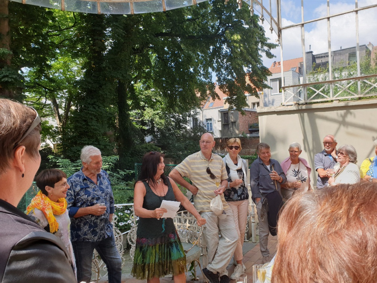 Groep vrijwilligers met in het midden Rita die zingt